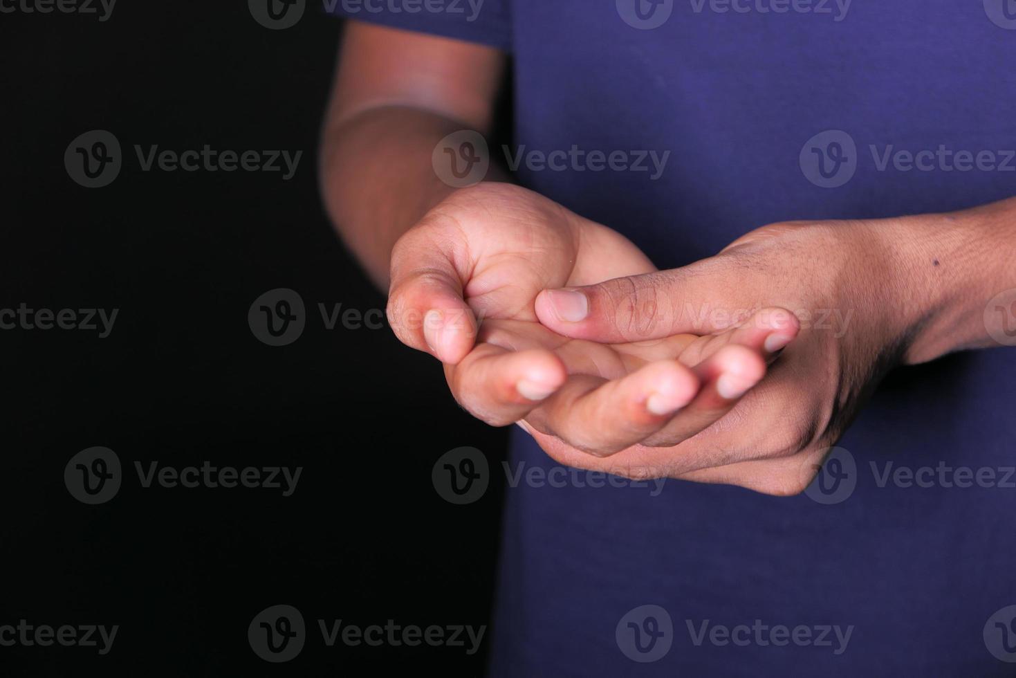 uomo con dolore alla mano su sfondo nero foto