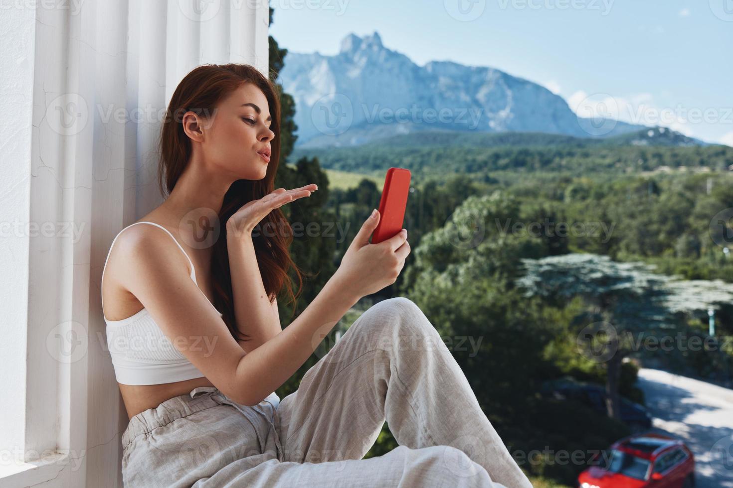 allegro donna uso il Telefono sembra a il schermo nel un' confortevole Hotel un Aperto Visualizza di il rilassamento concetto foto