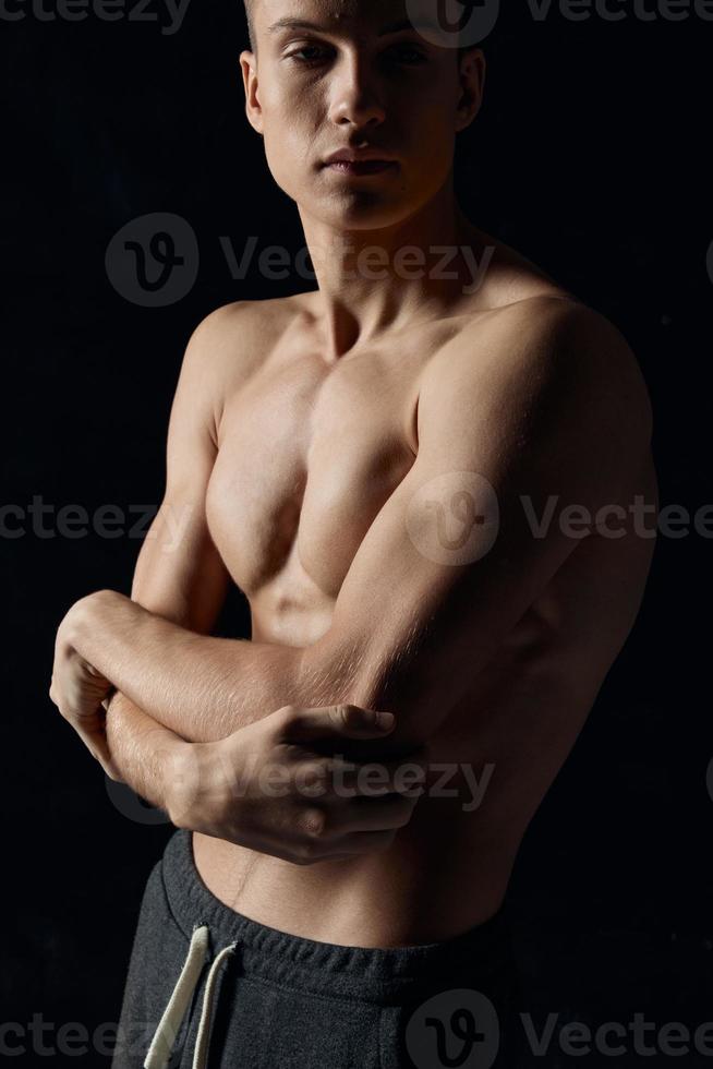 gli sport tipo su un' nero sfondo nudo torso fitness ginnastica braccia attraversato su il suo il petto foto