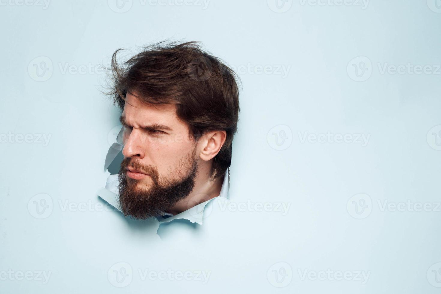un' barbuto uomo fa capolino su a partire dal dietro a il parete insoddisfazione emozioni ufficio ufficiale foto