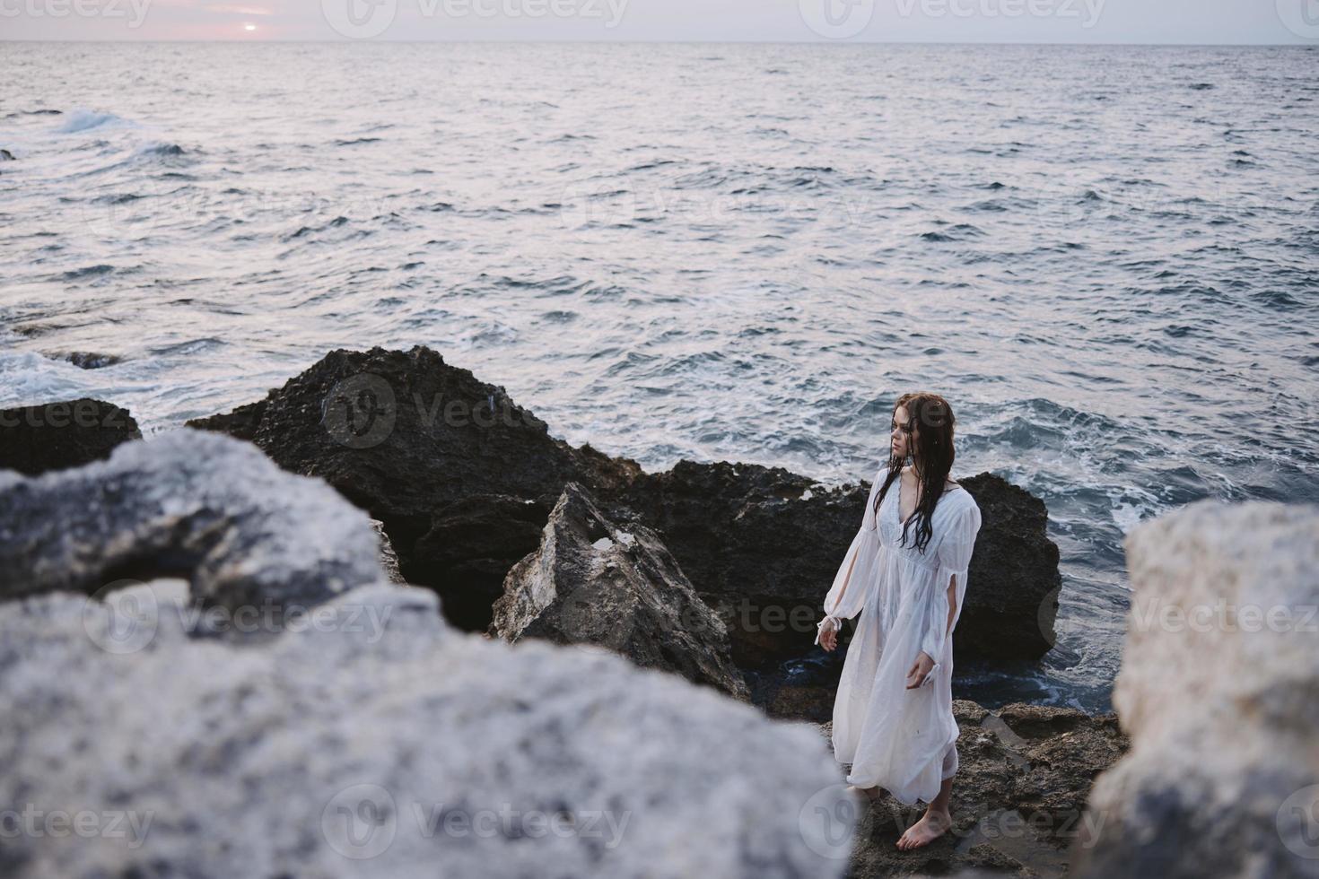 donna viaggiatore nel bianca vestito a il mare spiaggia la libertà foto