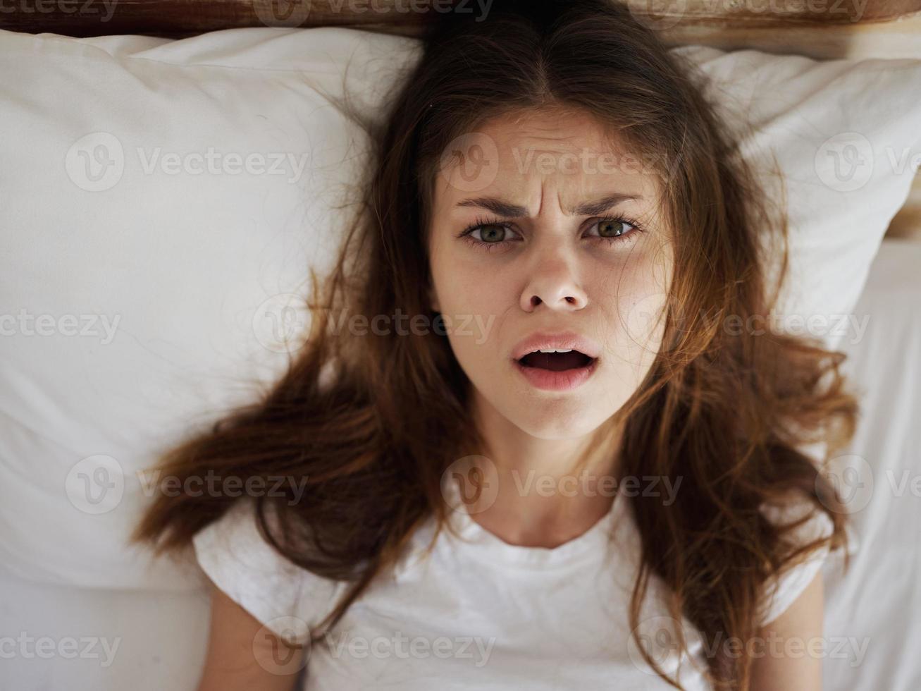 irritato donna con Aperto bocca bugie nel letto insoddisfazione avvicinamento foto