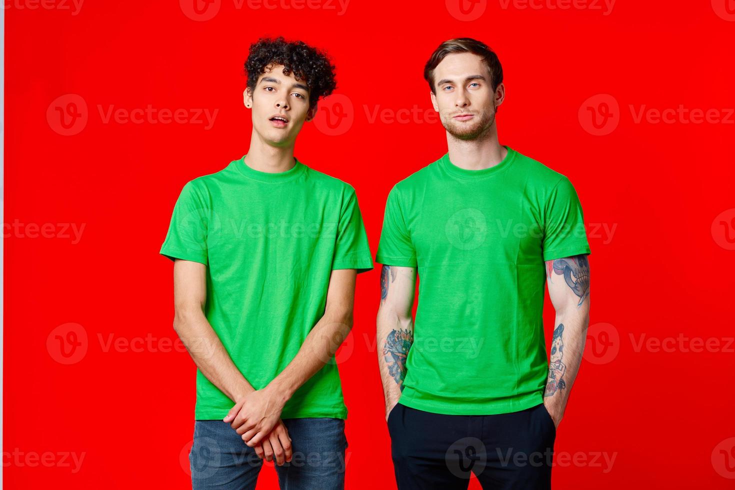 gioioso amici nel verde magliette siamo in piedi Il prossimo per rosso sfondo foto