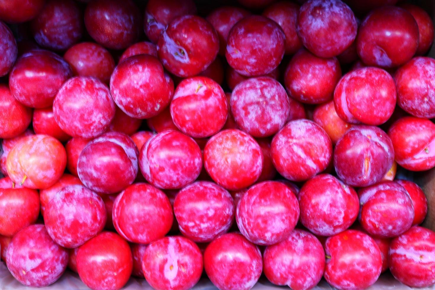 struttura di rosso prugna nel negozio vicino su superiore view.box con prugne nel memorizzare .gustoso dolce frutta per dolce, insalata ,succo foto