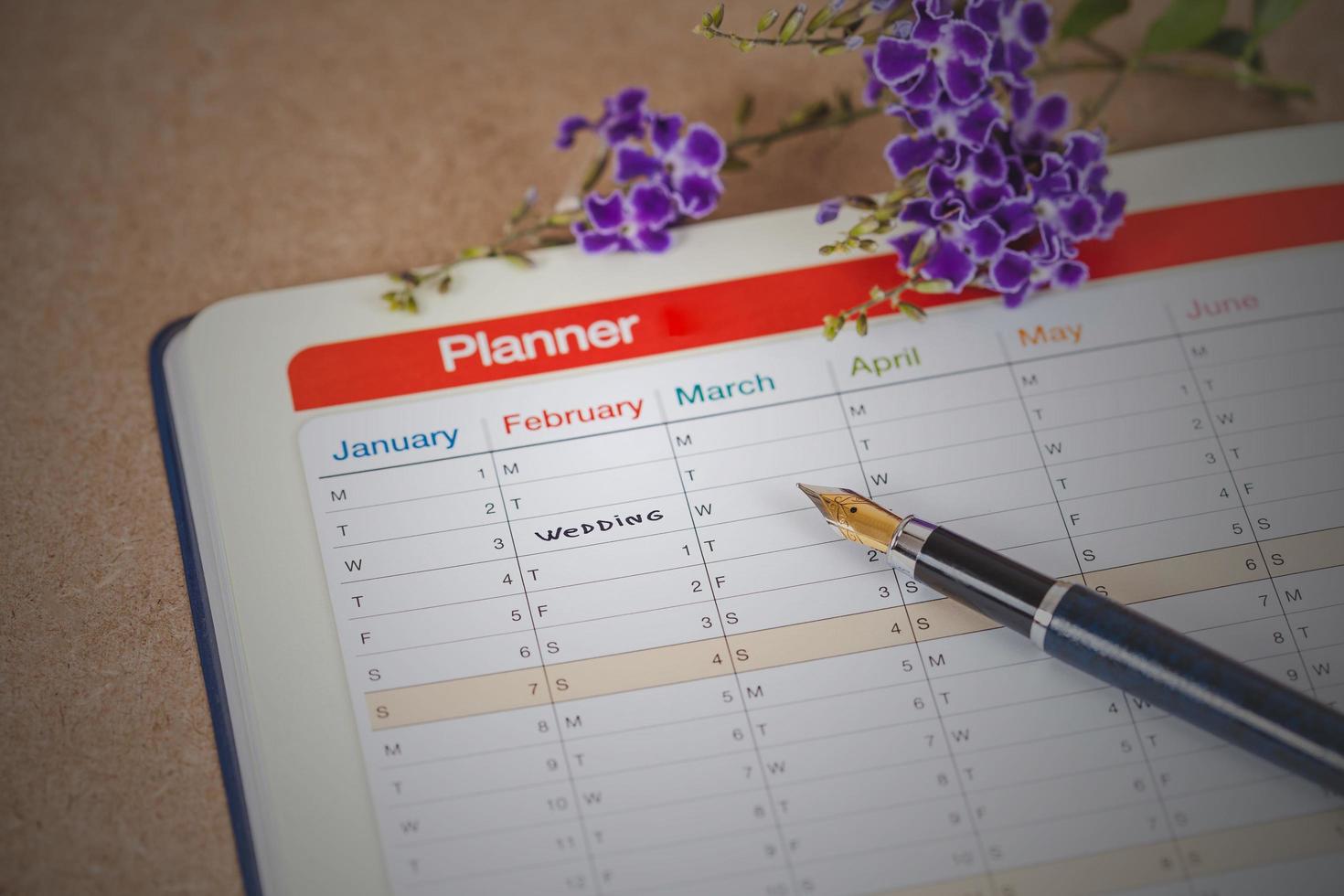 parola nozze su calendario con dolce fiori e penna ,amore concetto. foto