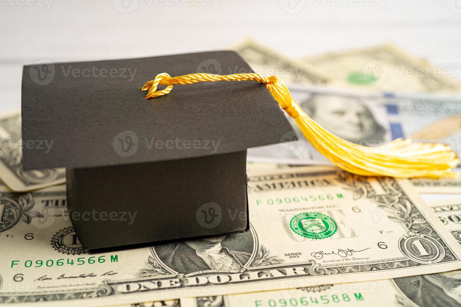 cappello di divario di laurea su banconote in euro e dollari americani, concetto di insegnamento della tassa di studio dell'istruzione. foto