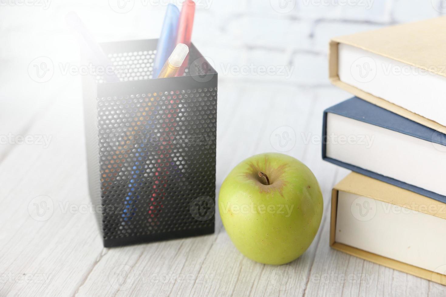 concetto di scuola con la mela sul blocco note sul tavolo foto