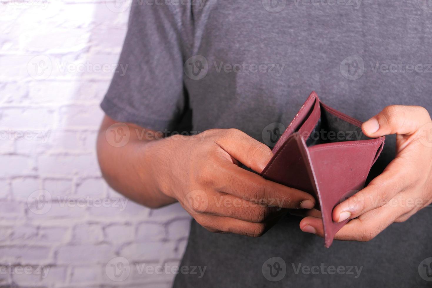 mano d'uomo aprendo un portafoglio vuoto con copia spazio foto