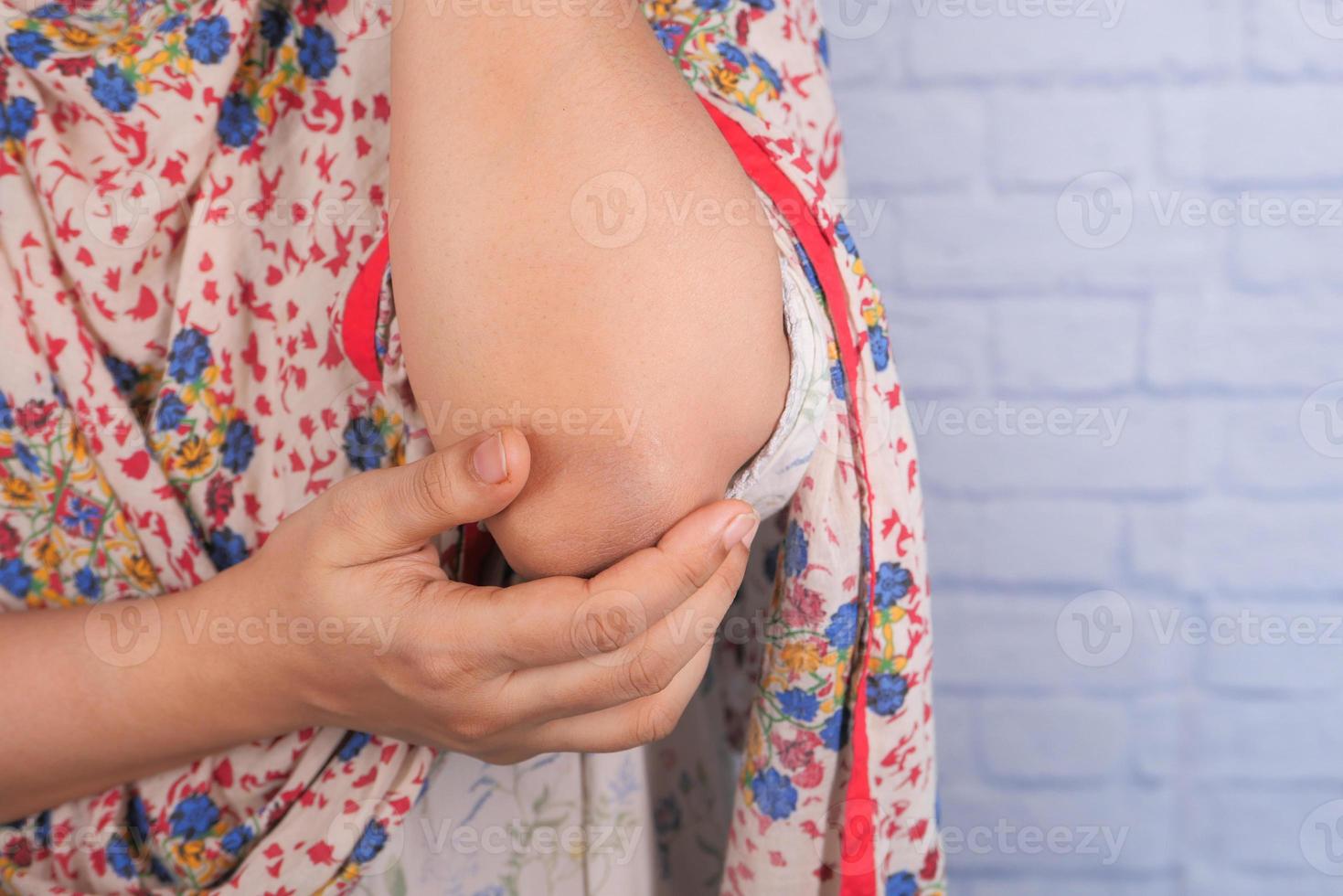 mano della donna che soffre di dolore al gomito con copia spazio foto