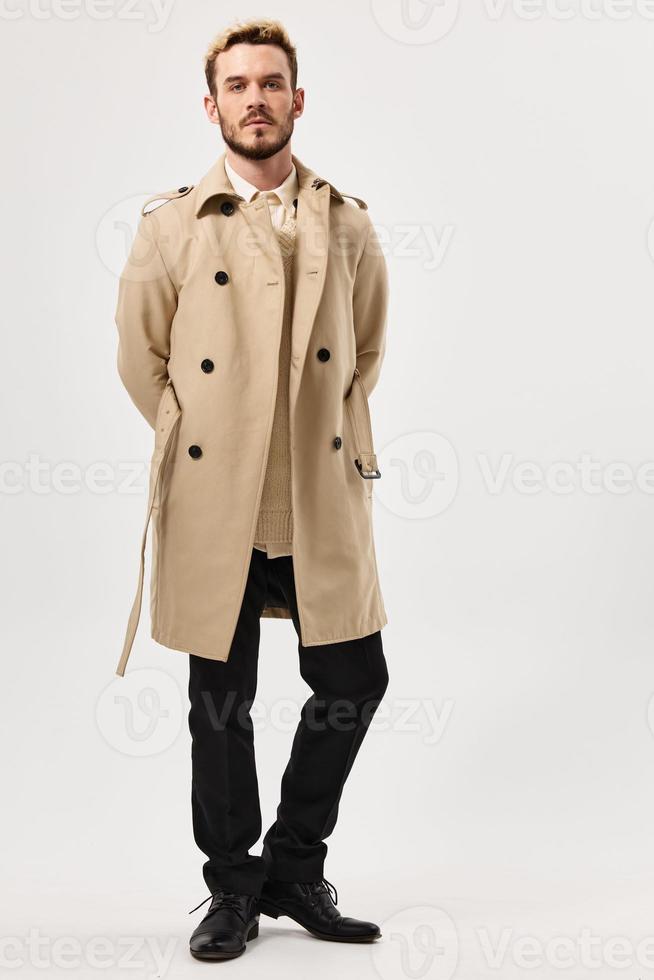 uomo con un' grave espressione beige cappotto moda moderno stile pieno lunghezza foto