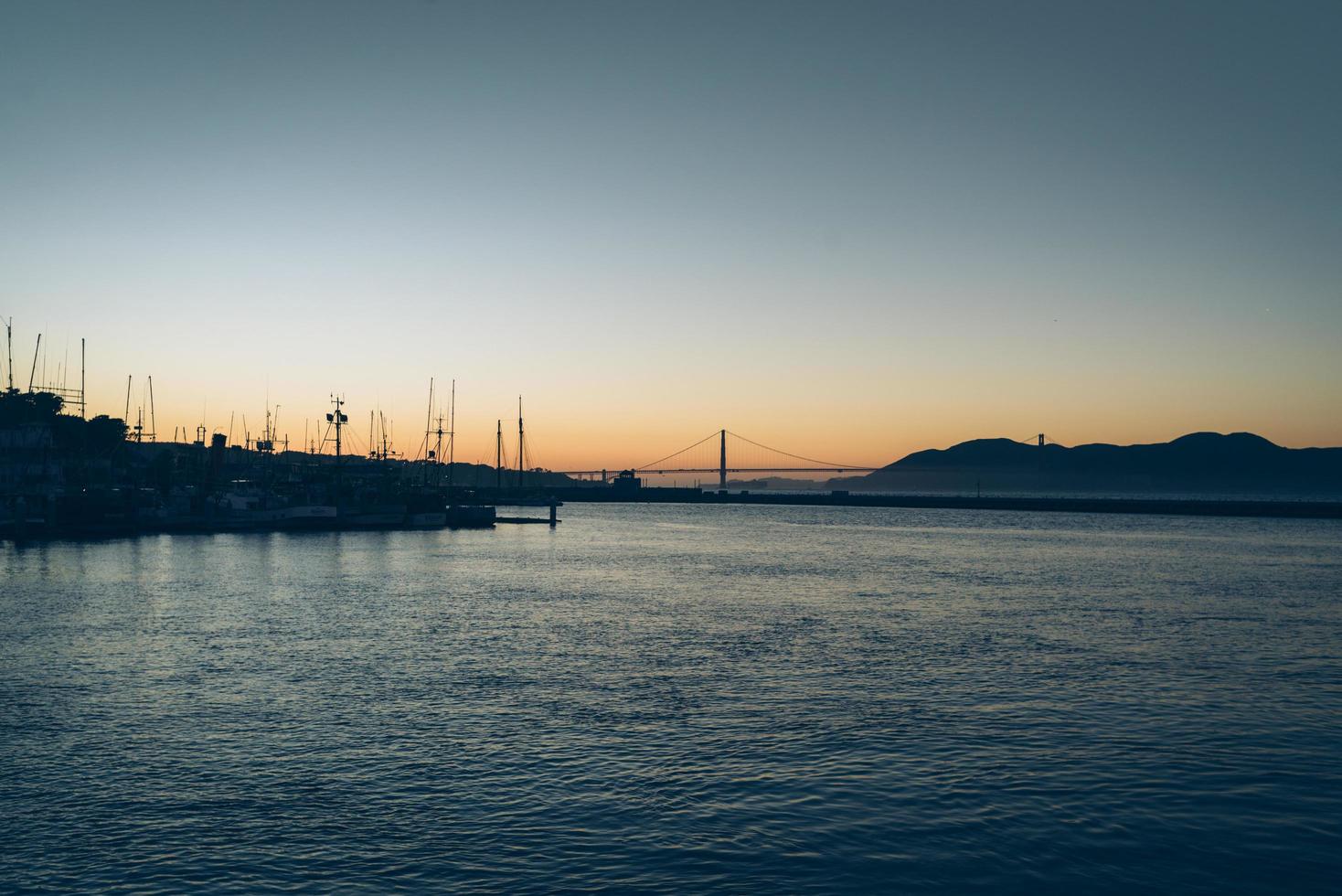 silhouette della città al tramonto sull'acqua foto