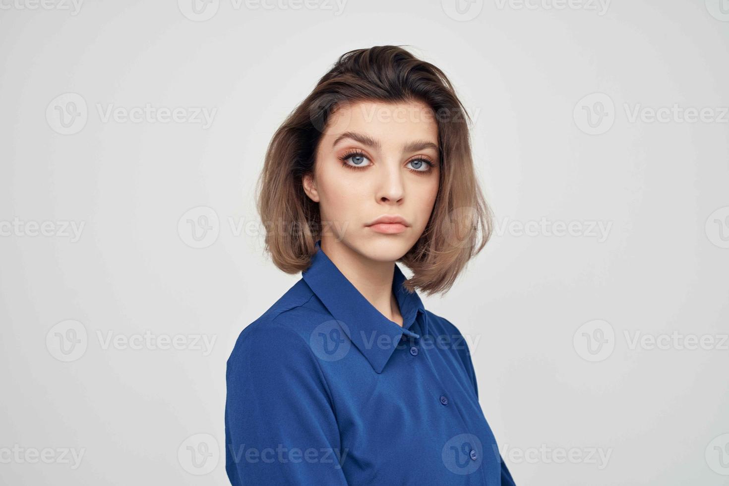donna nel blu camicia moda in posa leggero sfondo foto