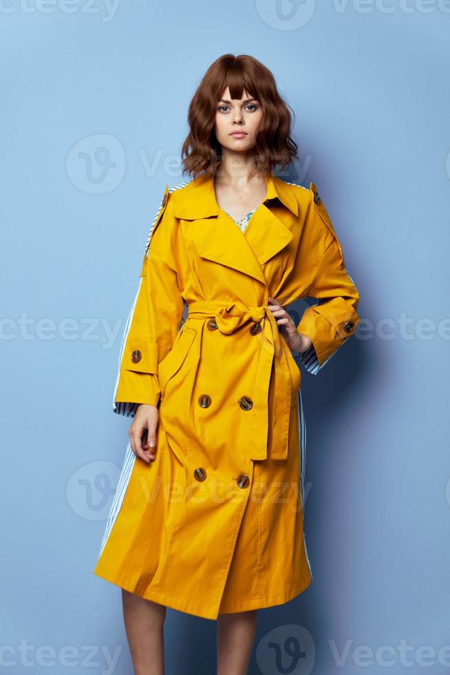 moda donna giallo cappotto mano su il cintura guardare inoltrare foto