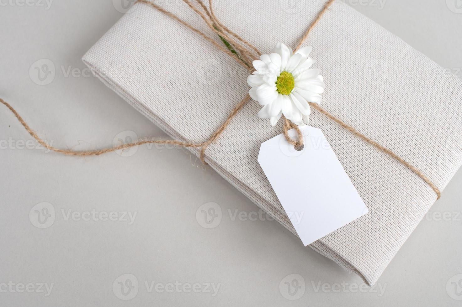 vuoto prezzo etichetta su bianca tessuto, regalo biancheria tessuto con un' etichetta su un' bianca sfondo con un' fiore foto