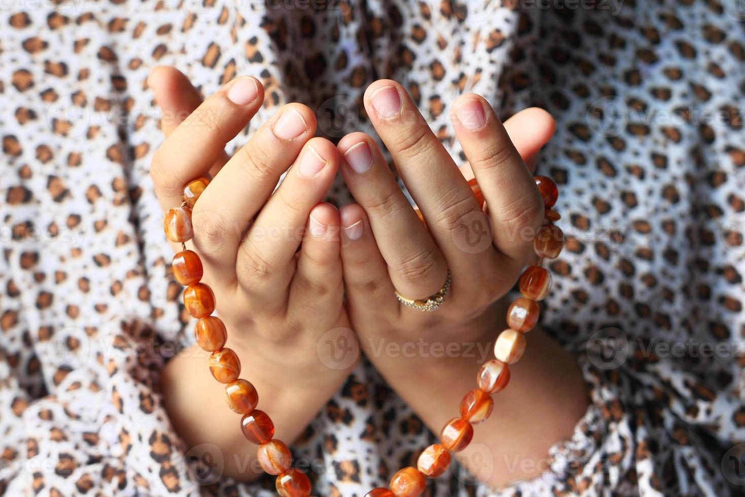 mani della donna che pregano con perline foto