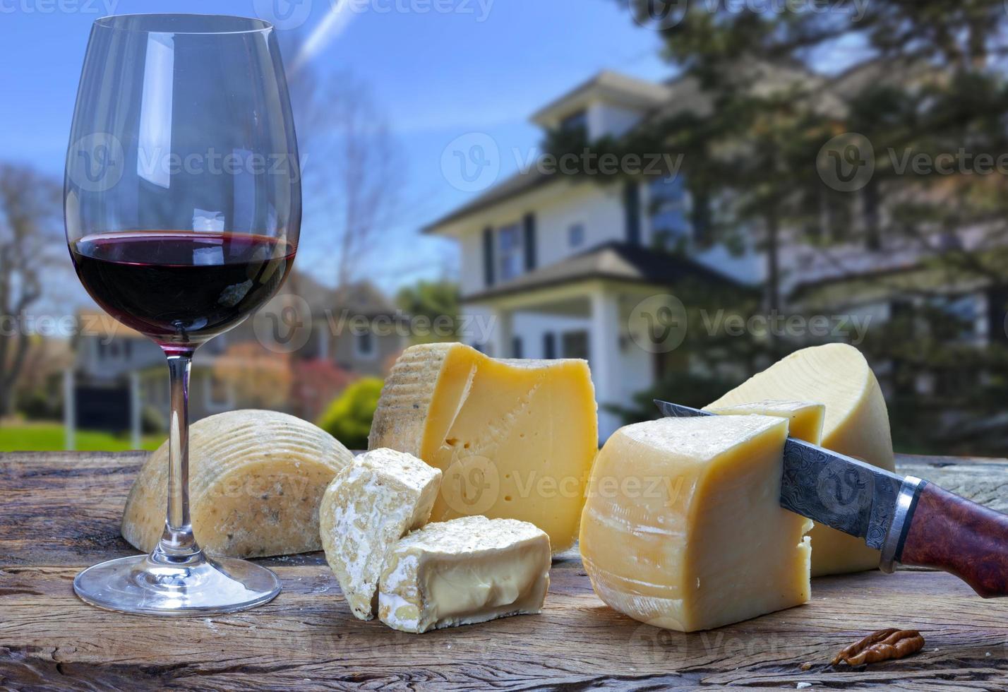 tavolo con un' bicchiere di rosso vino e vario formaggi foto