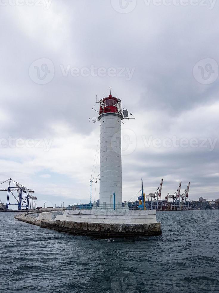 paesaggio marino mare con faro, calma acqua e bianca nuvole foto