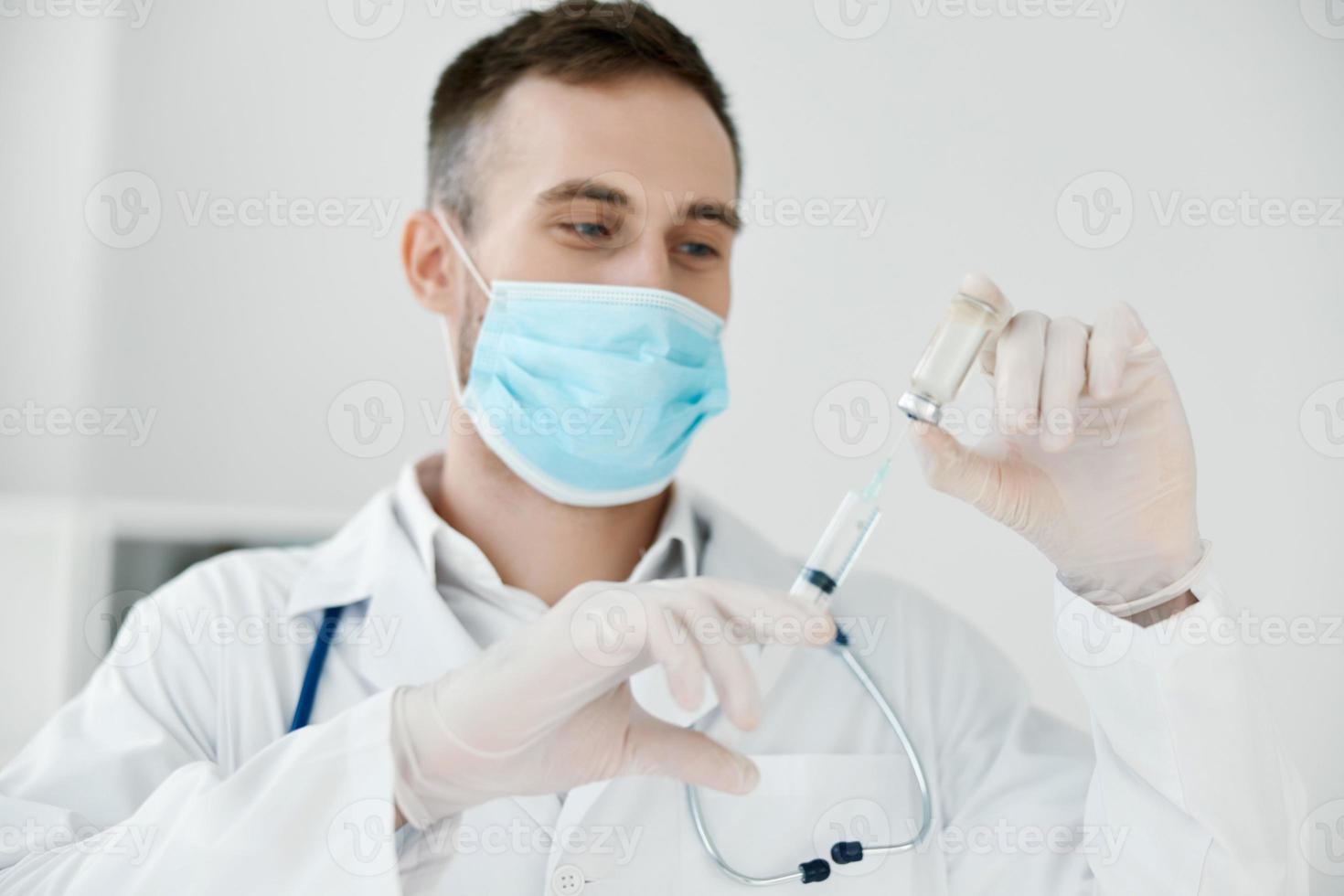 medico nel il laboratorio detiene un' siringa nel il suo mano medico maschera vaccino liquido foto