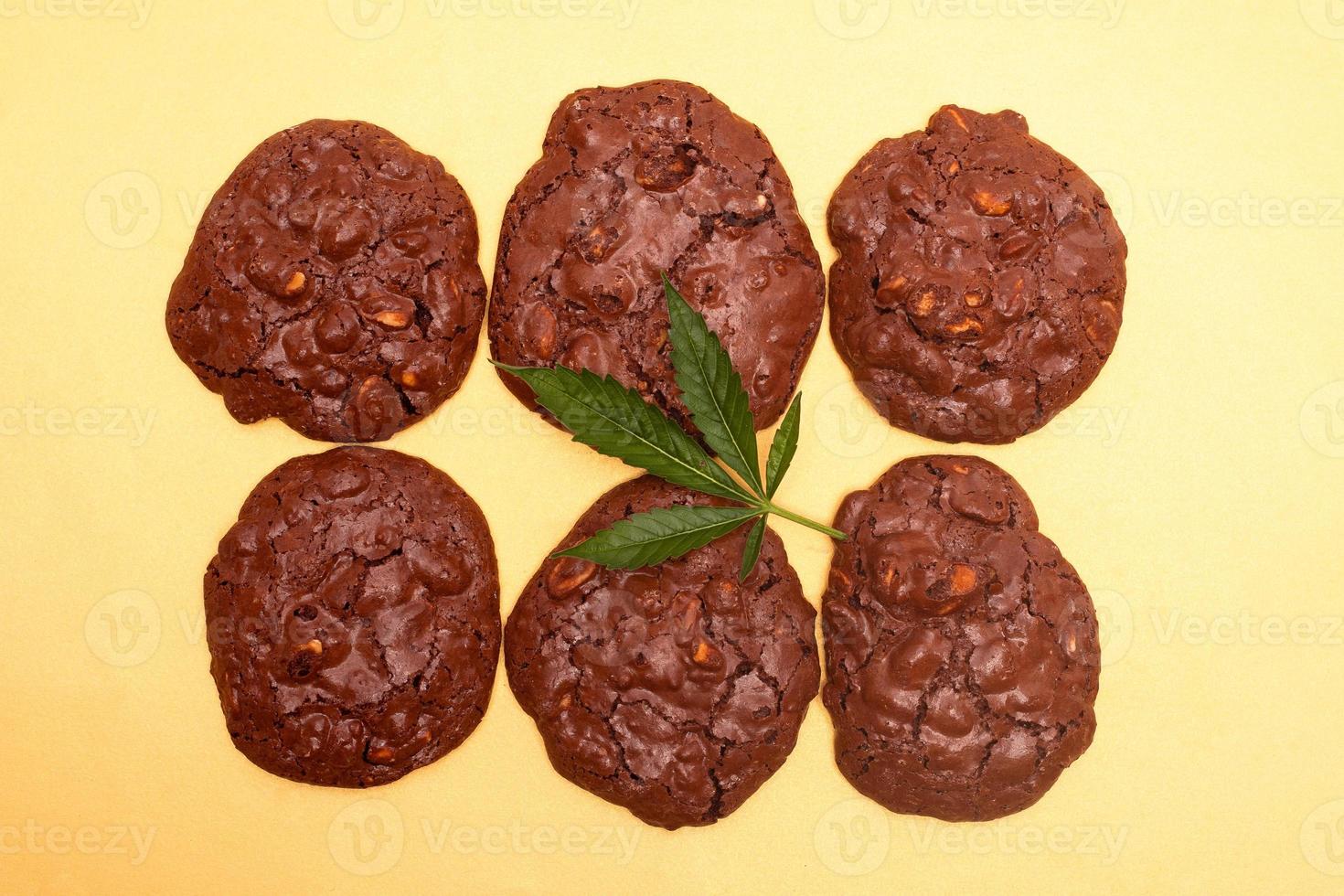 biscotti di farina d'avena e foglia verde di cannabis su uno sfondo giallo foto