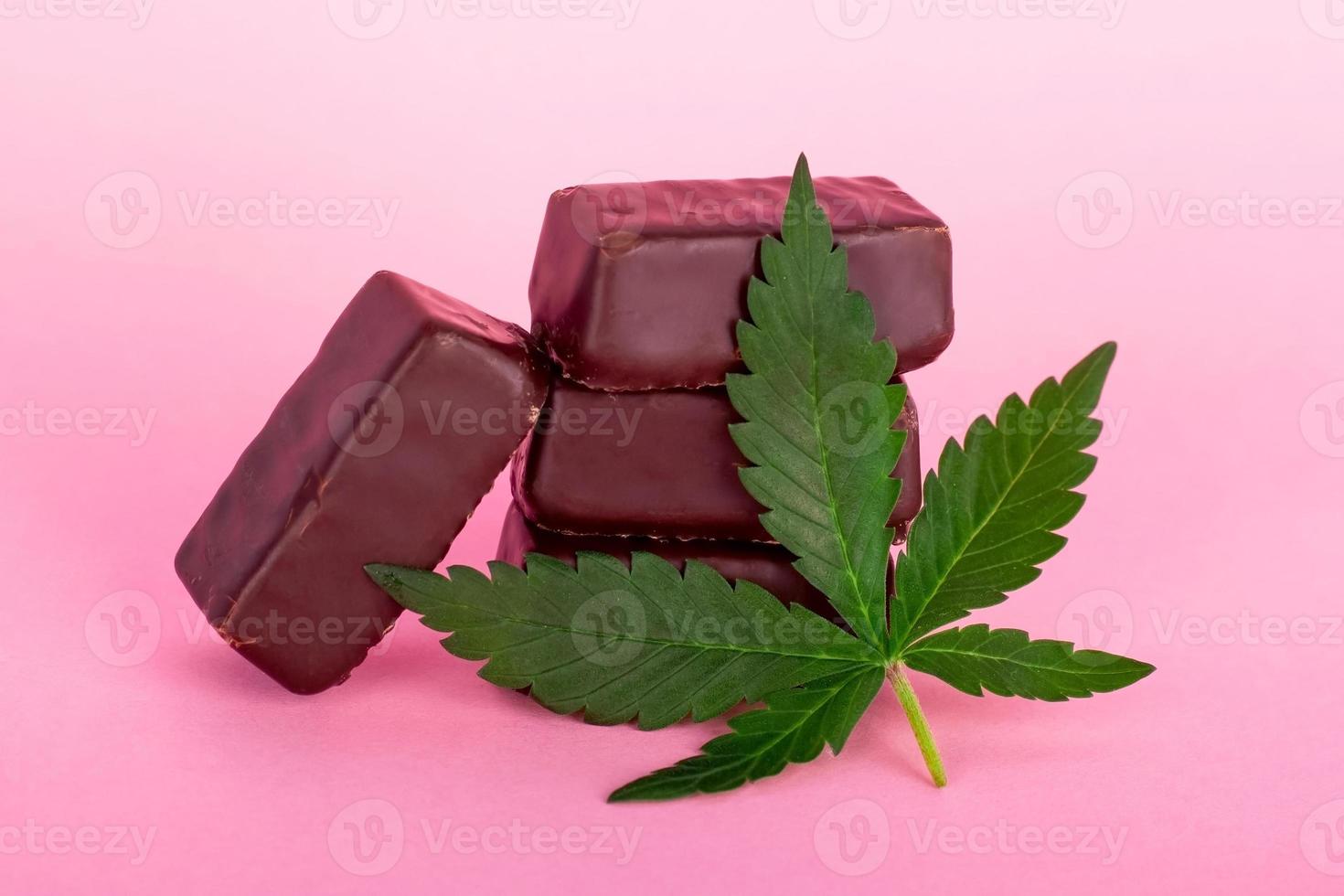 caramelle al cioccolato con cannabis medica su sfondo rosa foto