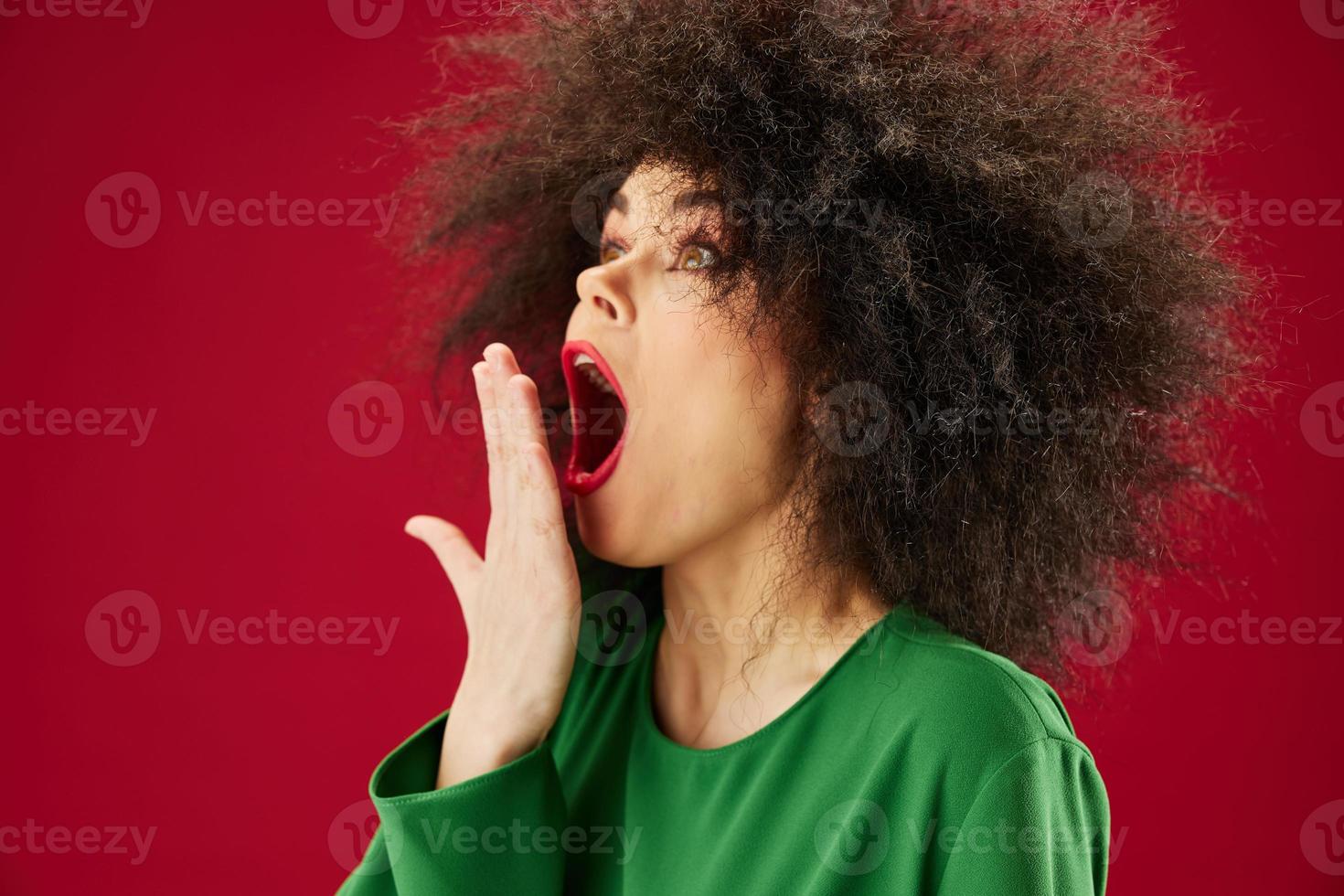 bella giovane femmina afro acconciatura verde vestito emozioni avvicinamento rosso sfondo inalterato foto