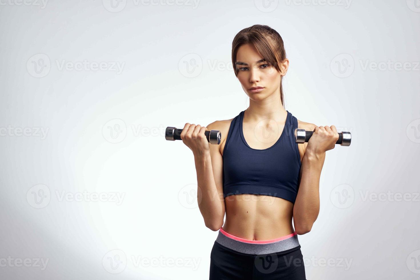 allegro donna con manubri nel mani pompato su stampa fitness esercizio Palestra foto
