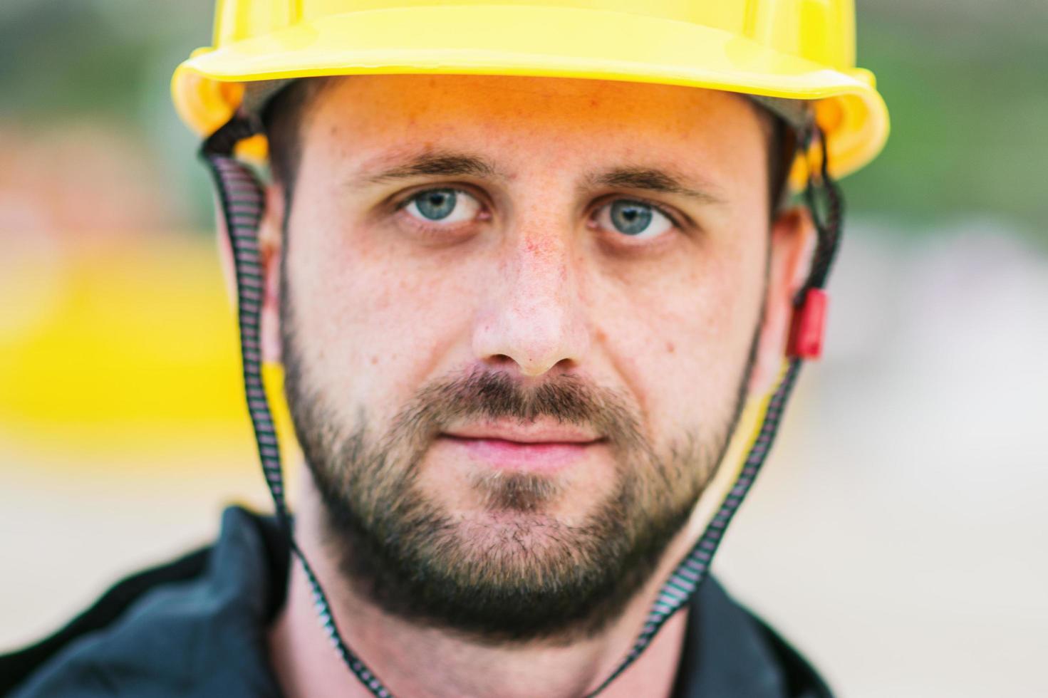 uomo giovane e bello in posa davanti a un edificio su cui sta lavorando foto