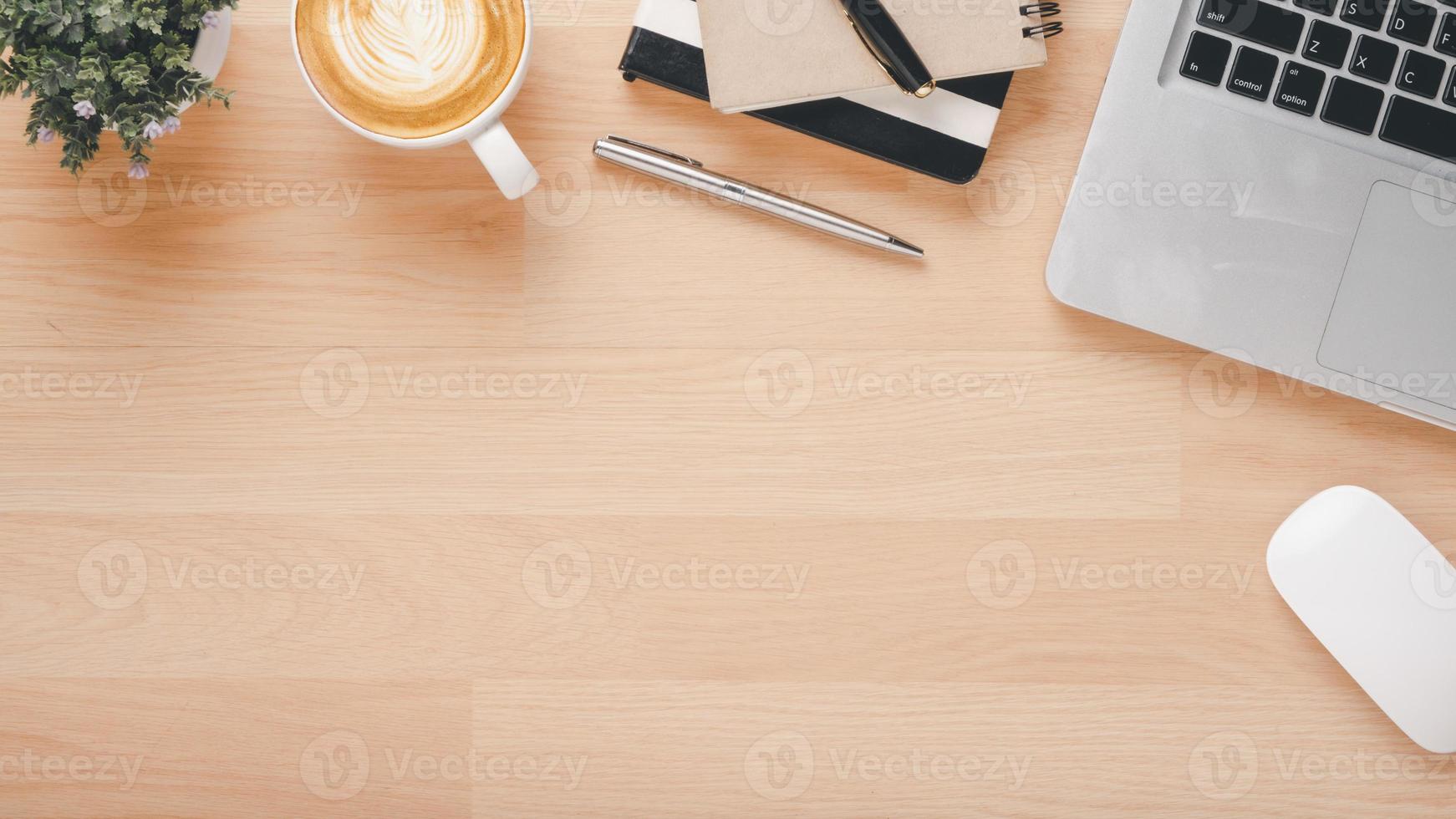 ufficio di legno scrivania posto di lavoro con il computer portatile computer, topo, taccuino, penna e tazza di caffè, superiore Visualizza piatto posare con copia spazio. foto