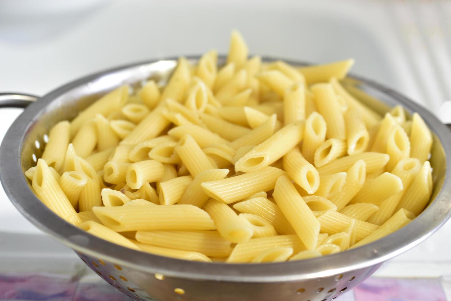 pasta italiana appena lavata in uno scolapasta in cucina foto