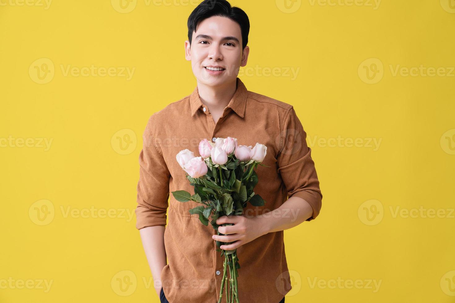 giovane asiatico uomo Tenere fiore su sfondo foto