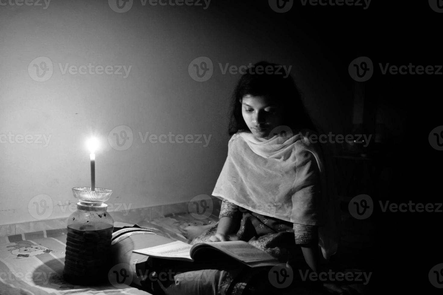 un' giovane ragazza studiando a casa con lume di candela dopo elettricità caricare muta a dhaka città. foto