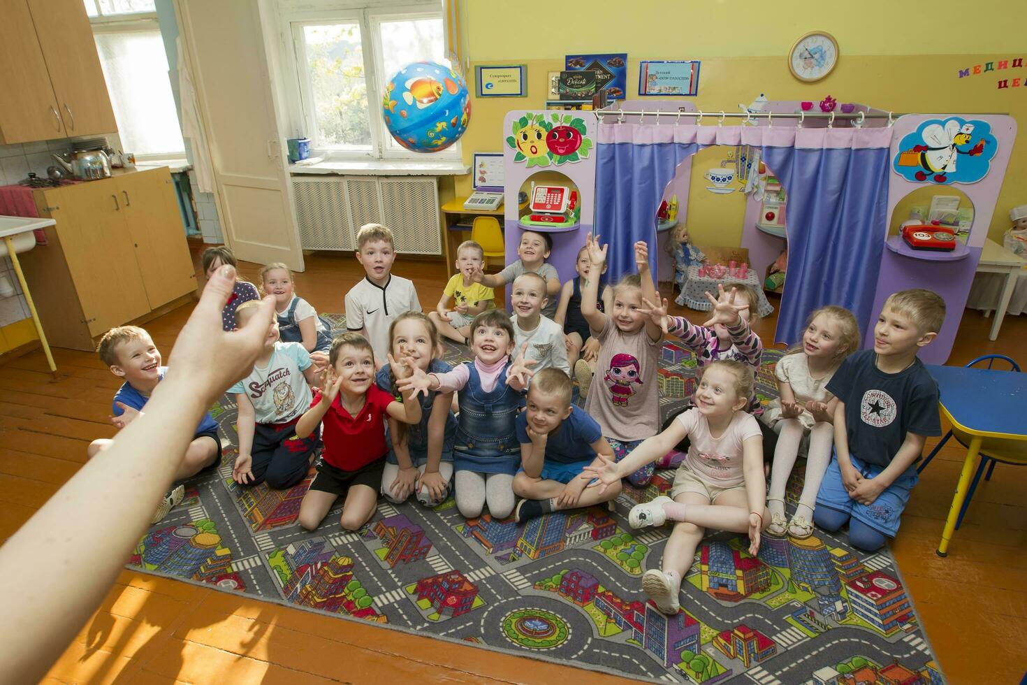 un' gruppo di bambini nel scuola materna giocando con un' sfera. foto