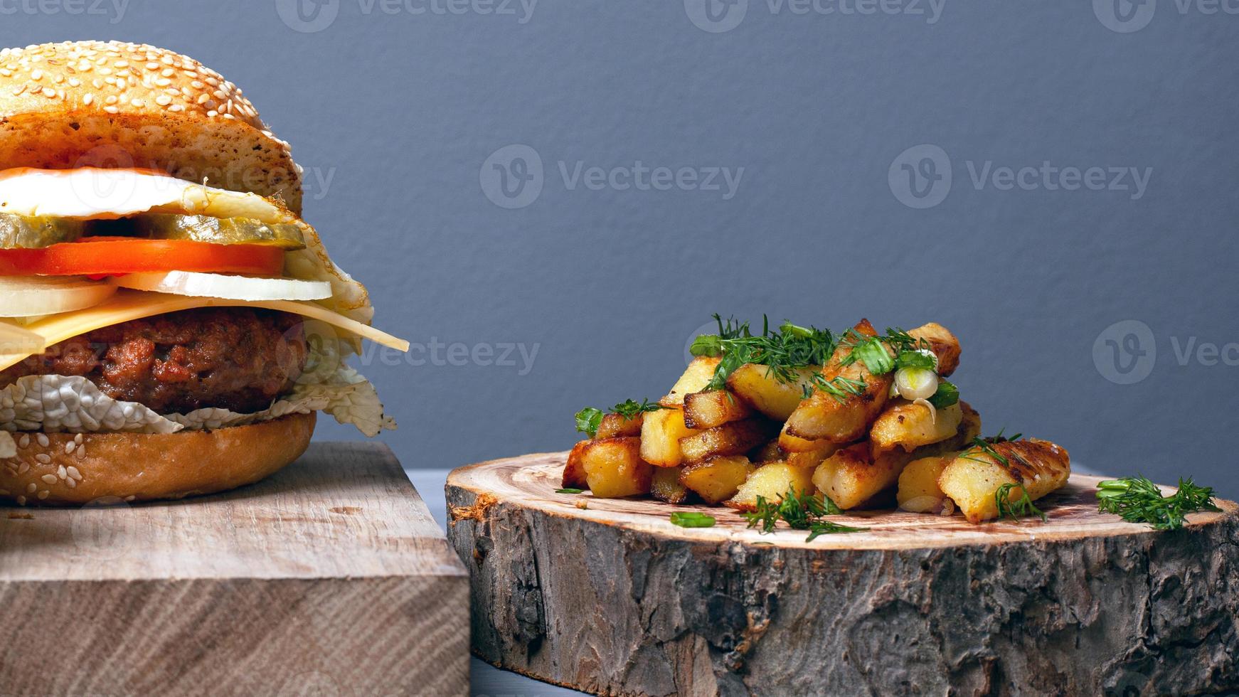 grande hamburger succoso con formaggio cotoletta, verdure e uova su uno sfondo grigio di close-up foto