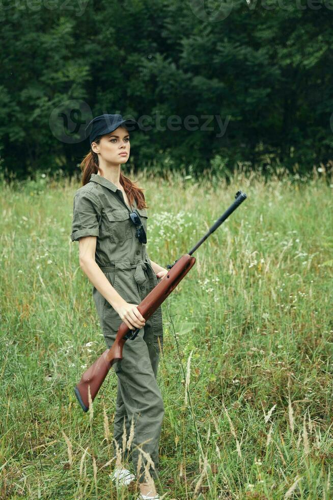 donna verde tuta nero berretto arma a caccia Armi foto