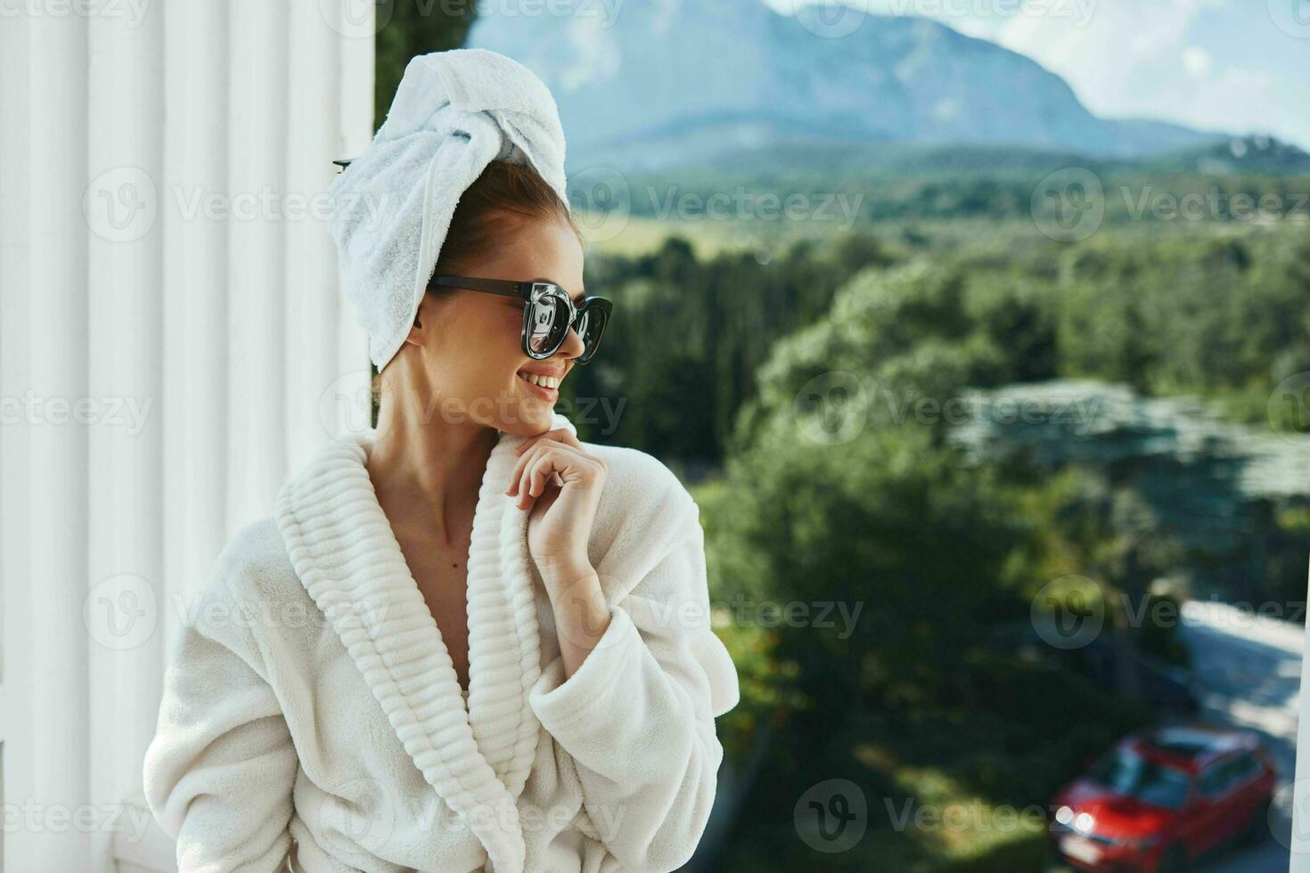 bellissimo donna in posa contro il fondale di montagne su il balcone architettura inalterato foto