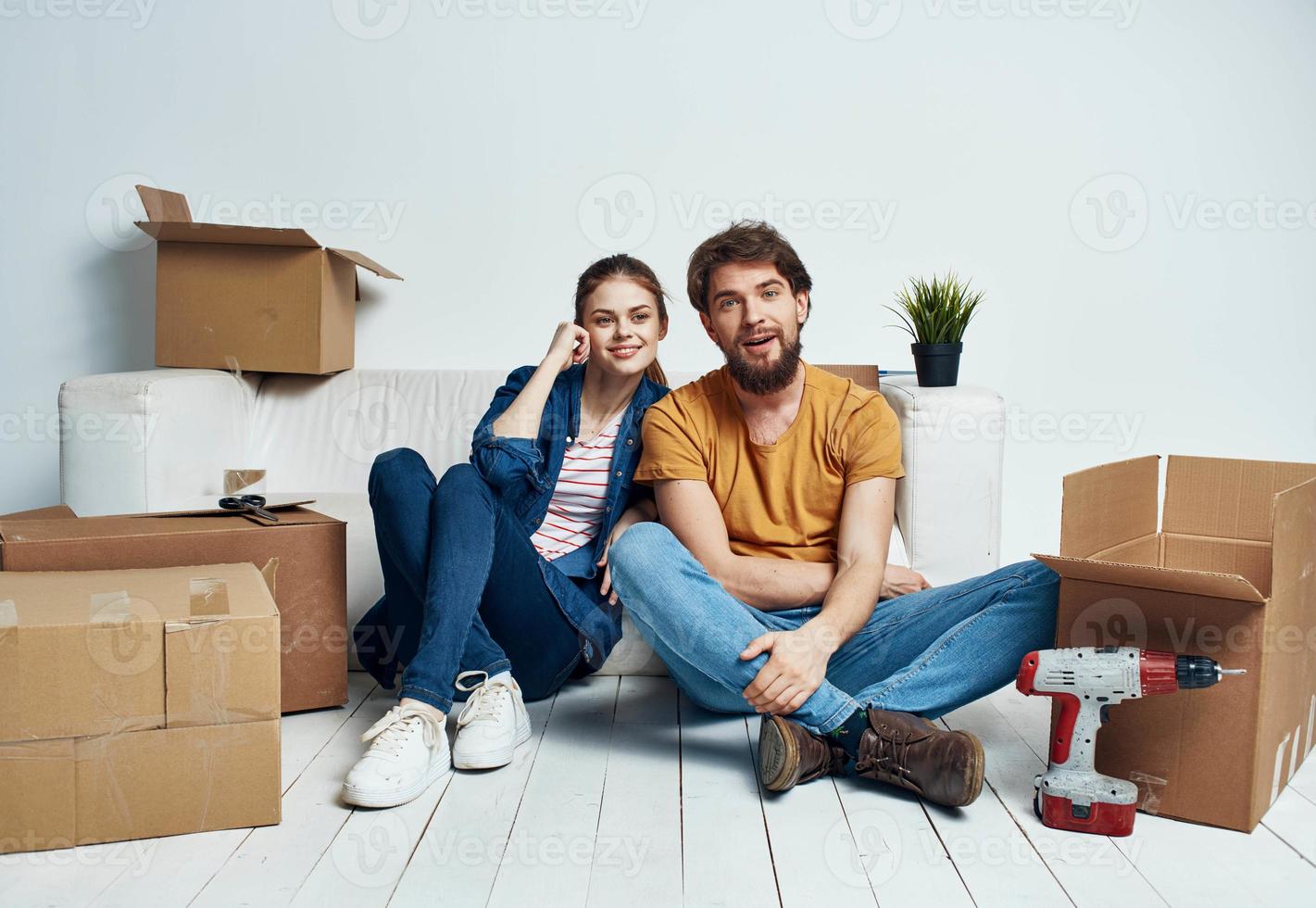 un' uomo e un' donna con scatole siamo in movimento. bene, un appartamento è essere ristrutturato di un' famiglia foto