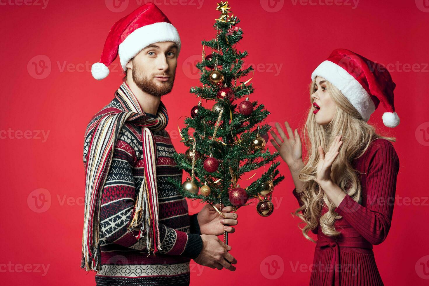 giovane sposato coppia Natale albero giocattoli vacanza gioia rosso sfondo foto