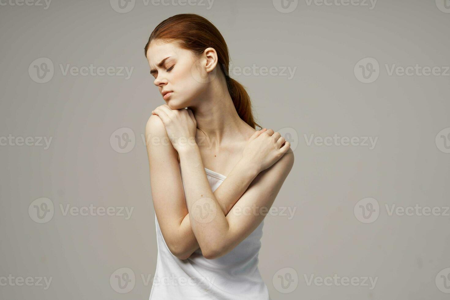 donna nel bianca maglietta Tenere su per il collo Salute i problemi comune studio trattamento foto
