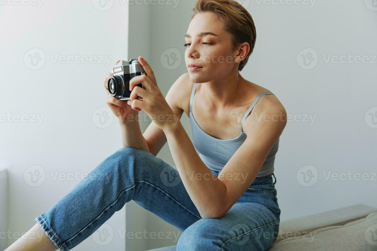 donna fotografo tiro nel studio su vecchio film telecamera a casa su divano ritratto, bianca sfondo, gratuito copia spazio, libero professionista fotografo foto