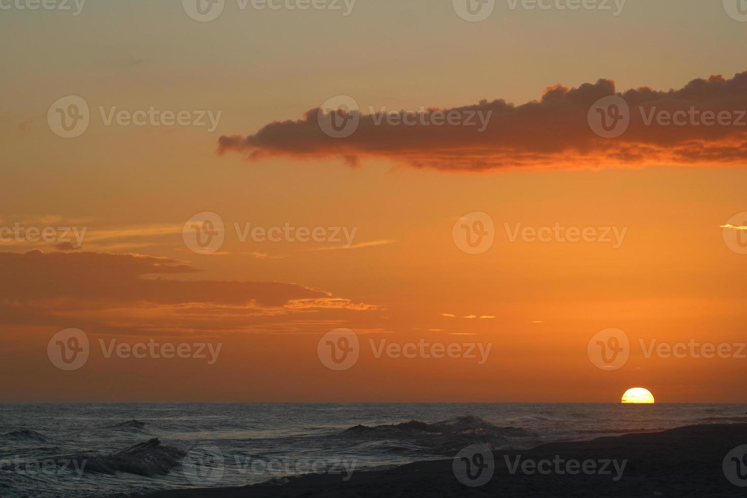 spiaggia tramonto con alcuni nuvole persone silhouette foto