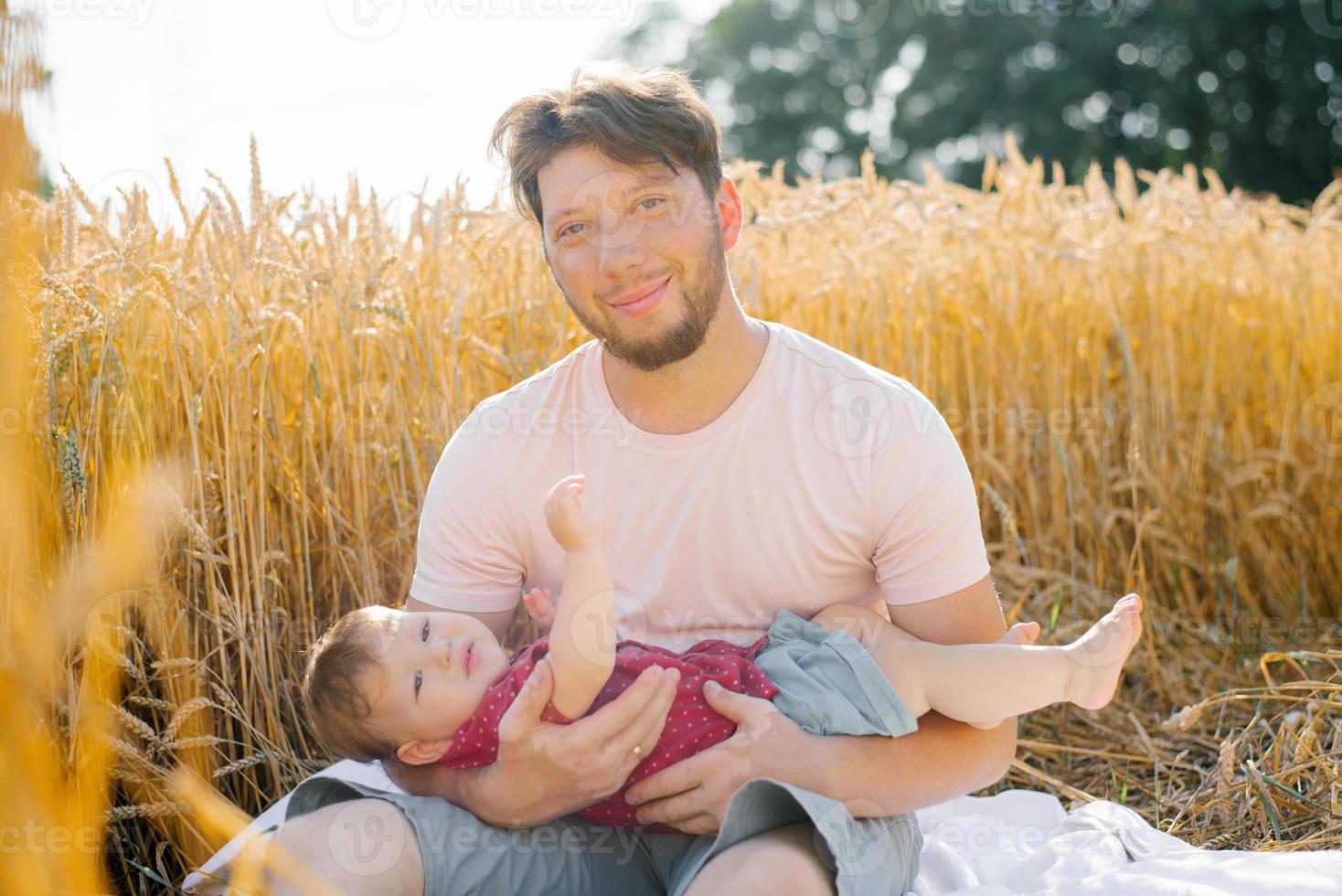 un' giovane papà e il suo figlio siamo seduta nel natura nel il estate nel il campo. foto