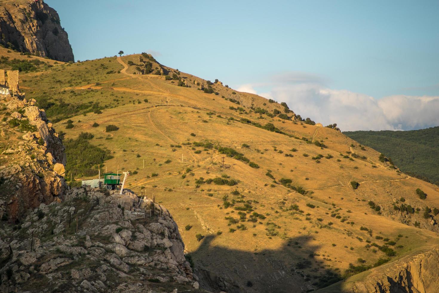 vista della fortezza genovese sul lato di una montagna con un cielo blu nuvoloso in crimea foto