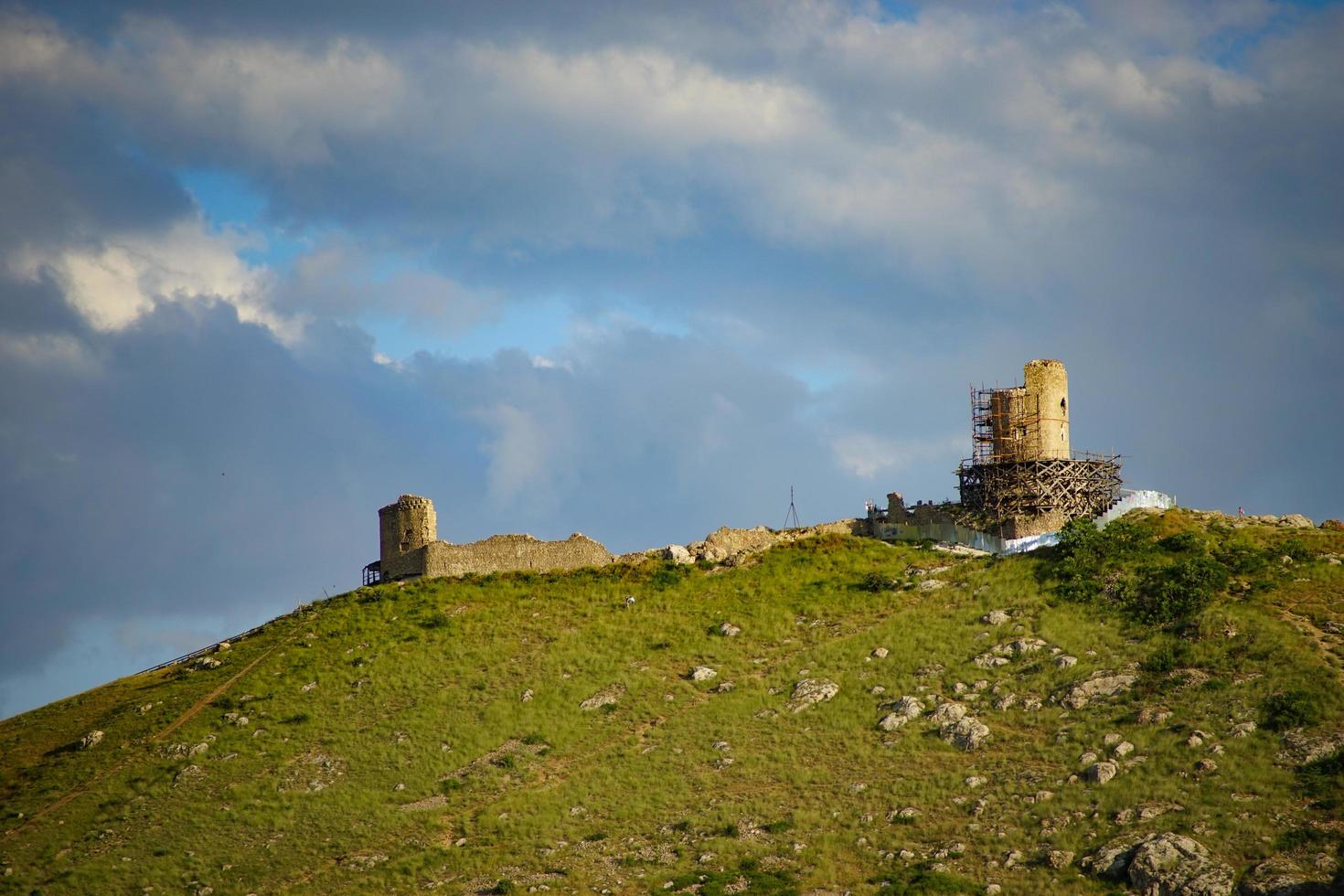 vista della fortezza genovese sul lato di una montagna con un cielo blu nuvoloso in crimea foto