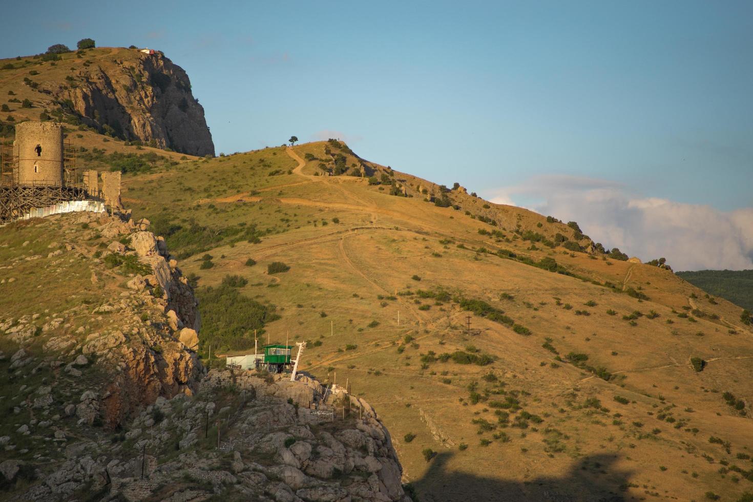 vista della fortezza genovese sul lato di una montagna con un cielo blu nuvoloso in crimea foto