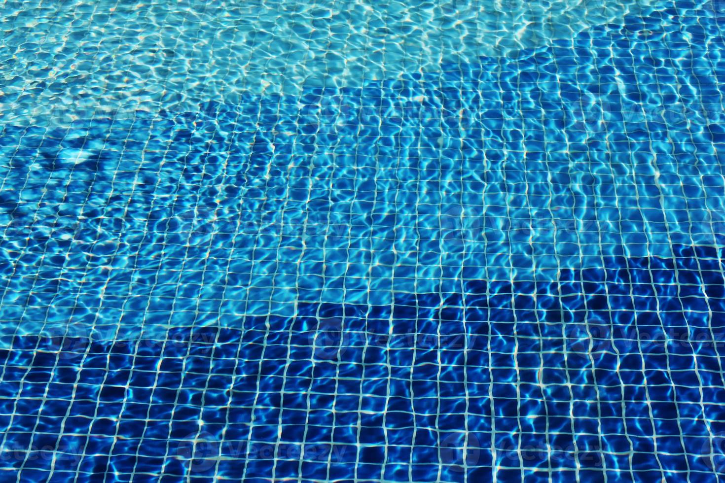 caustiche del fondo del mosaico della piscina acqua di mare increspata. flusso con onde, sport e concetto di relax. sfondo estivo. la consistenza della superficie dell'acqua. vista dall'alto. foto