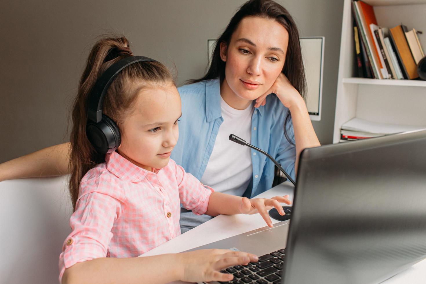 mamma che assiste il bambino con l'e-learning foto