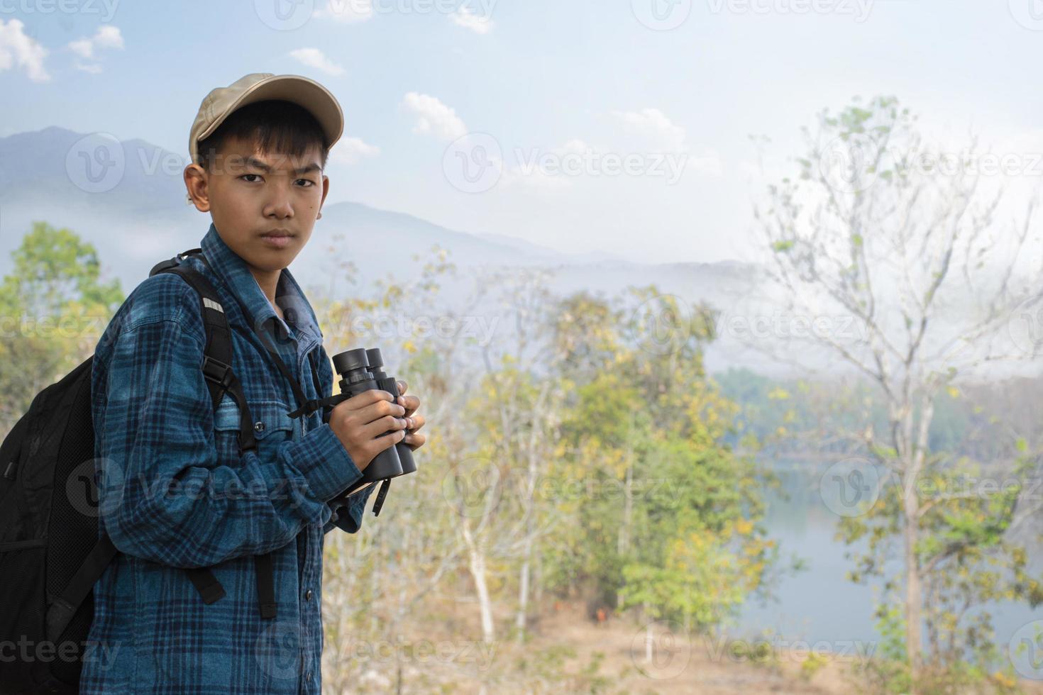 asiatico ragazzi utilizzando binocolo per fare il osservazione uccelli nel tropicale foresta durante estate campo, idea per apprendimento creature, natura animali e insetti al di fuori il aula. foto