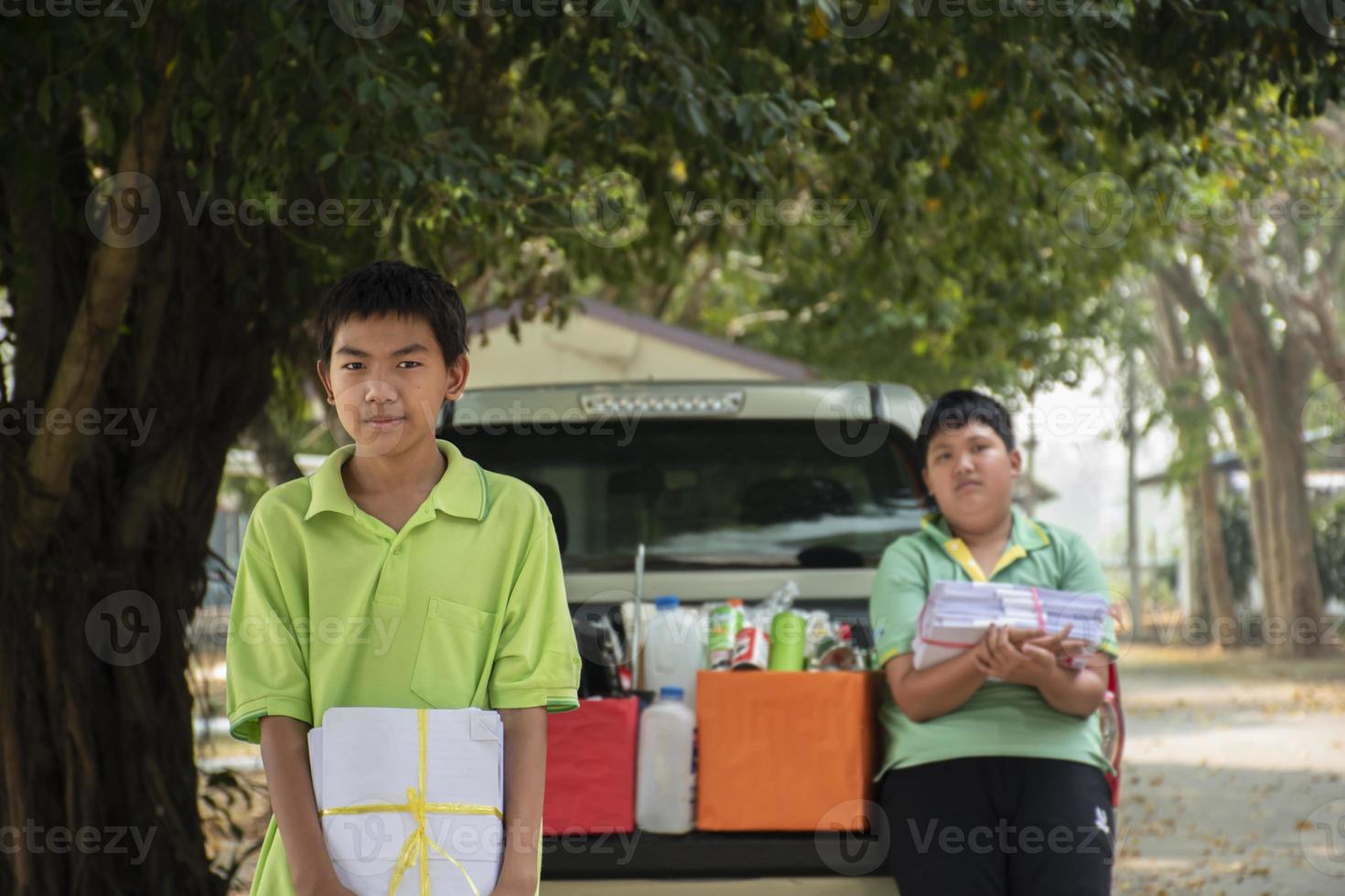 asiatico ragazzi siamo separare spazzatura e mettendo loro in il scatole nel davanti di loro vicino costruzione, morbido e selettivo messa a fuoco, ambiente cura, Comunità servizio e estate vacanza attività concetto. foto