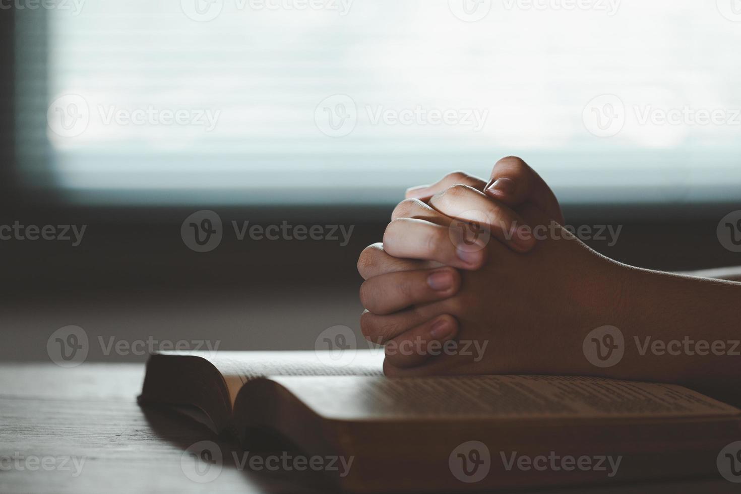 giovane donna persona mano preghiere su santo Bibbia con studia. adulto femmina cristiano lettura libro nel Chiesa. ragazza apprendimento religione spiritualità con pregare per Dio. concetto di alunno formazione scolastica fede. foto