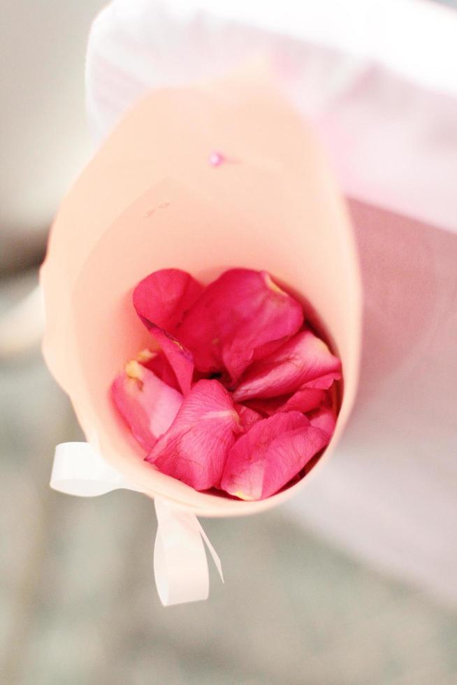 bellissimo rosa rosa petali fiori decorato su bianca sedia nel nozze cerimonia foto